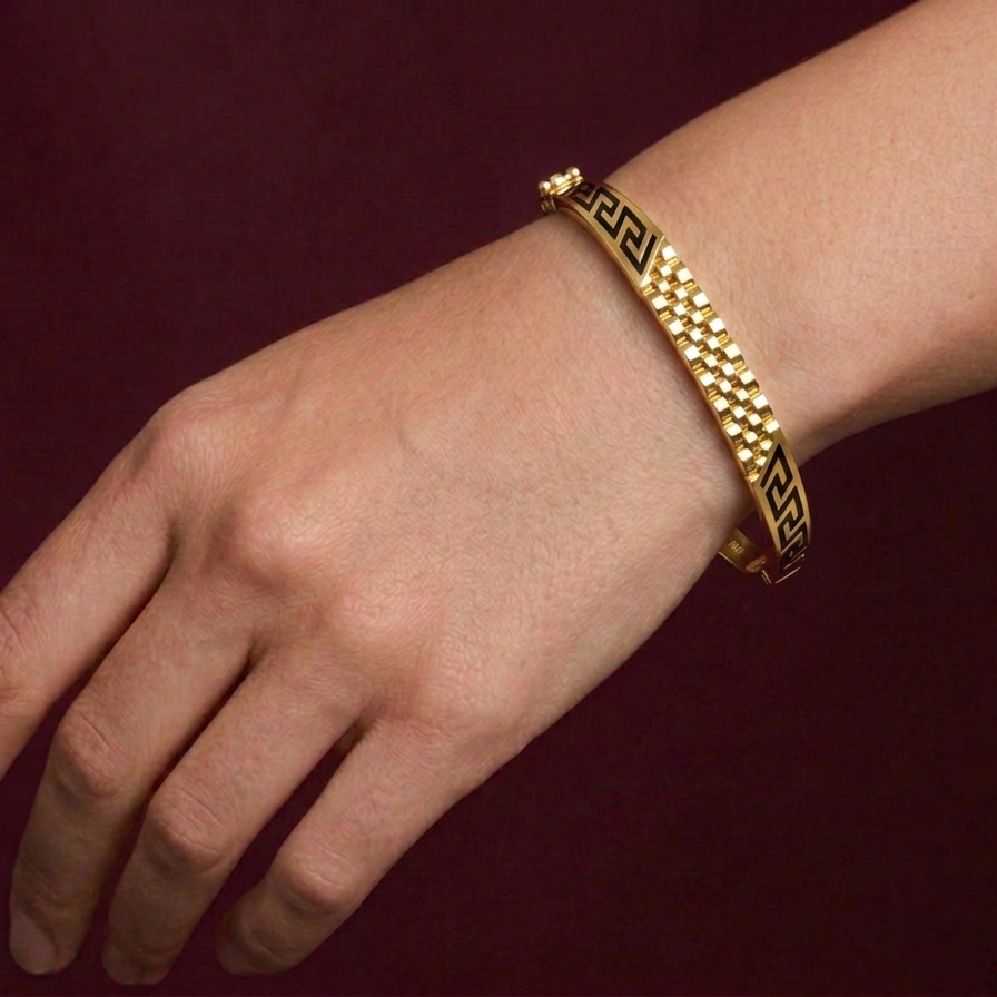 Gold butterfly bracelet on a wrist against a dark background