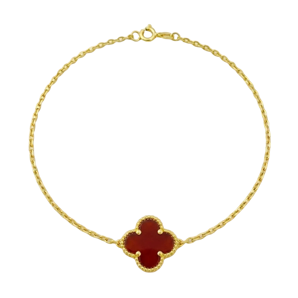 Gold bracelet with a red clover-shaped charm on a white background