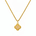 Gold necklace with a four-leaf clover pendant on a white background
