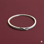 Silver bracelet with small stones on a maroon background