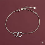 Silver bracelet with heart designs on a maroon background