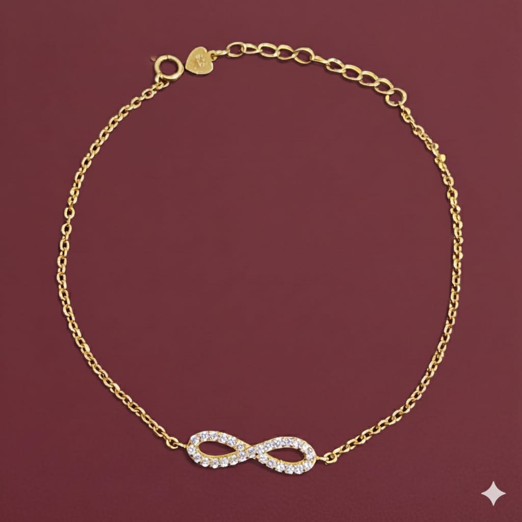 Gold bracelet with heart charm on wrist against a neutral background