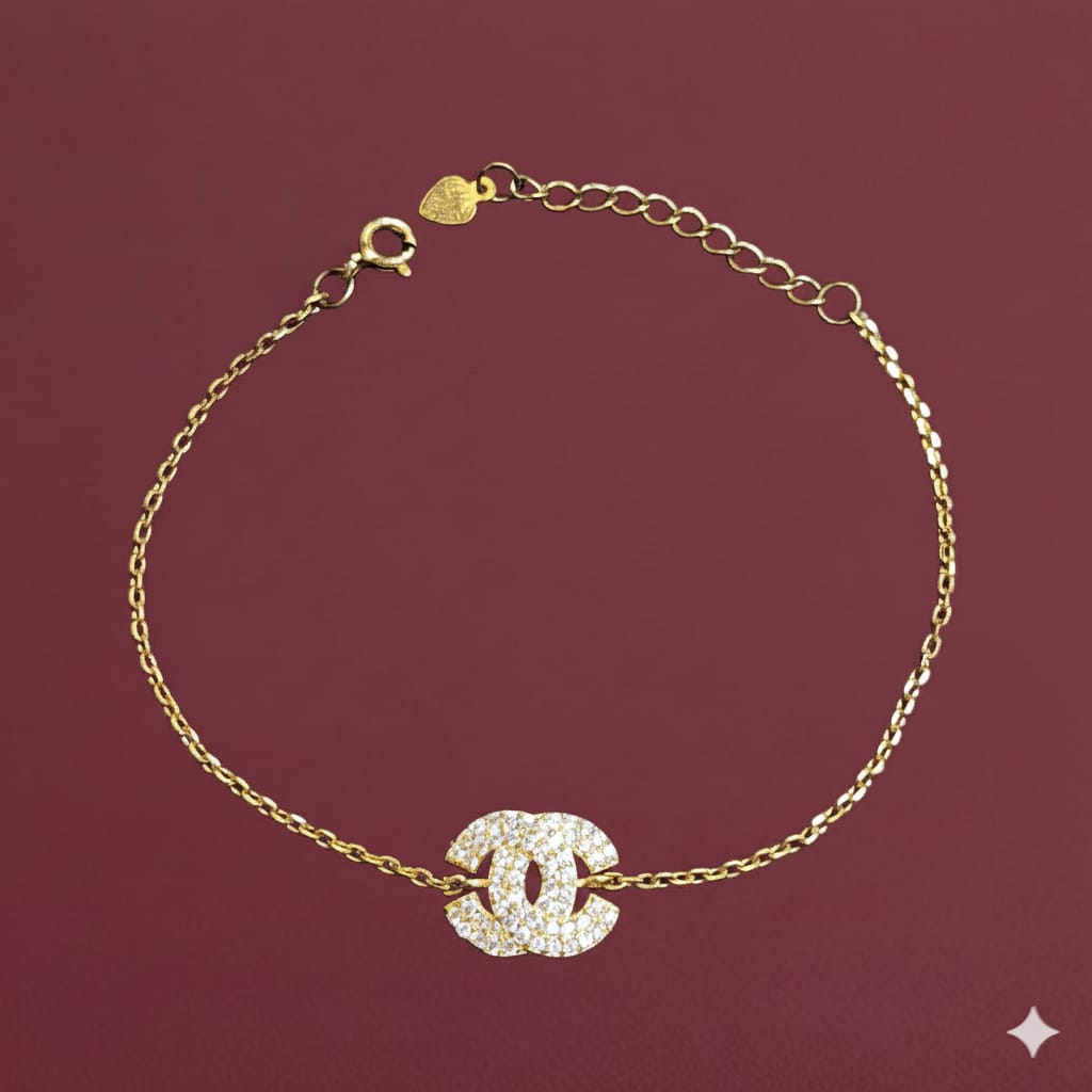 Gold bracelet with a diamond-studded clasp on a maroon background