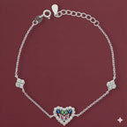 Silver bracelet with a heart-shaped clasp featuring colorful stones on a maroon background