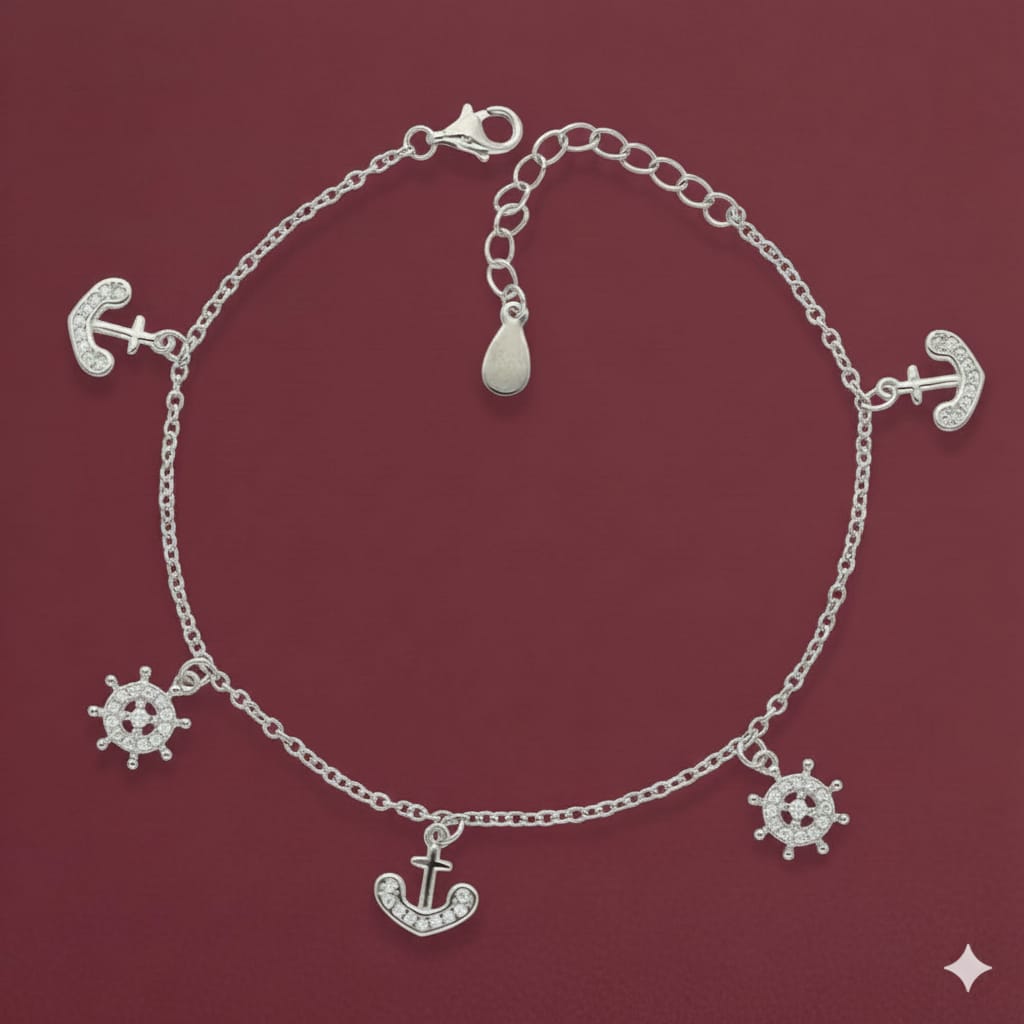 Silver bracelet with anchor and wheel charms on a red background