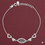 Silver bracelet with heart and eye design on a maroon background