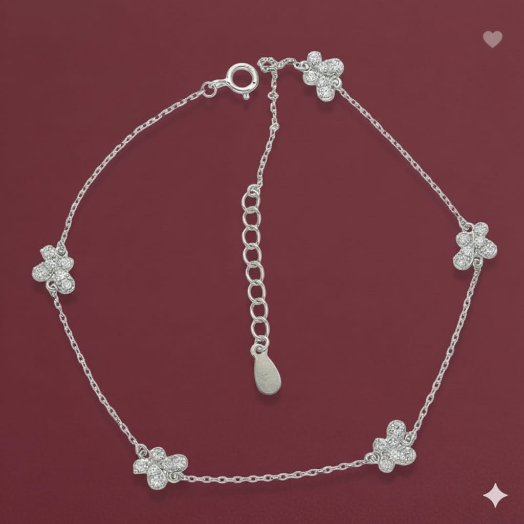 Silver bracelet with flower-shaped charms on a red background