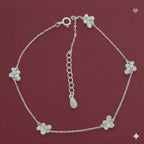 Silver bracelet with flower-shaped charms on a red background