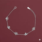 Silver bracelet with floral designs on a maroon background