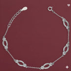 Silver bracelet with diamond-like stones on a maroon background