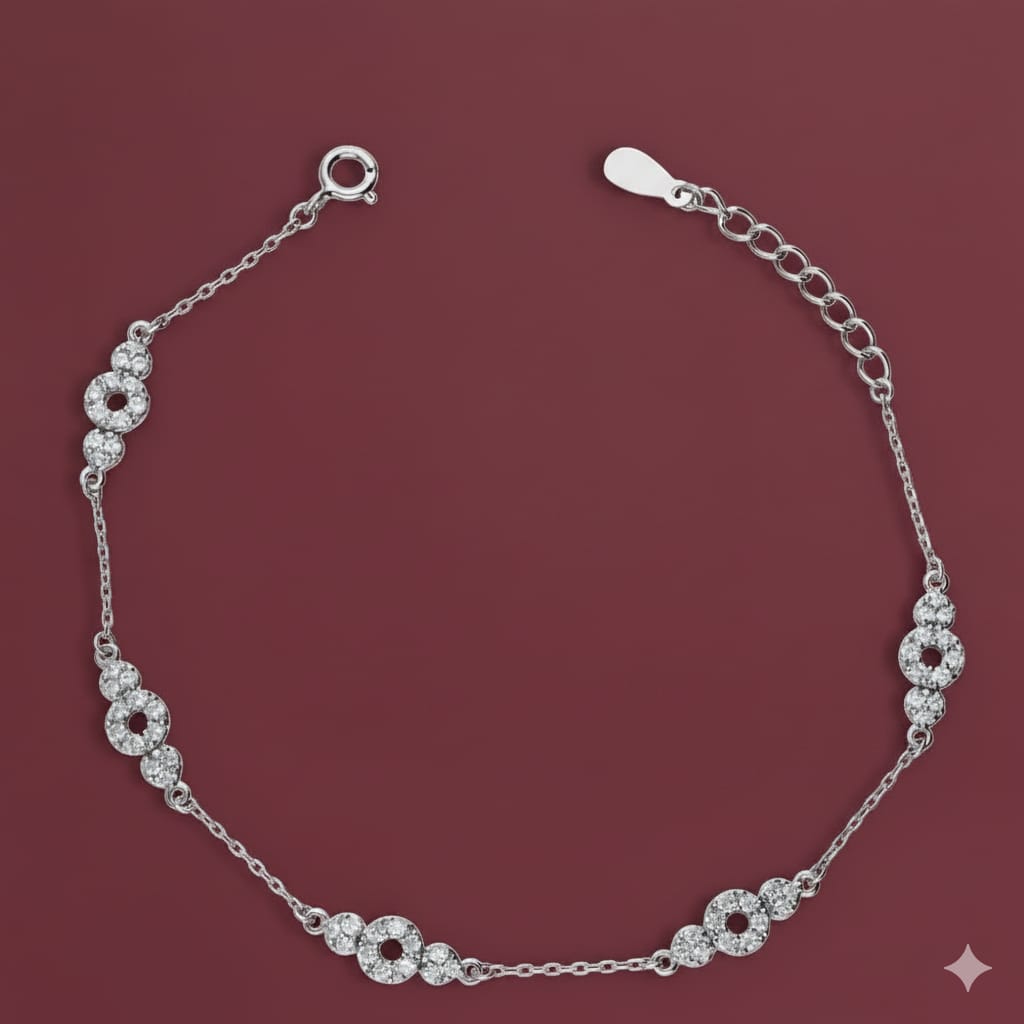 Silver bracelet with floral designs on a maroon background