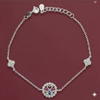 Silver bracelet with a decorative clasp on a maroon background