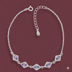 Silver bracelet with purple gemstones on a maroon background