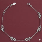 Silver bracelet with elephant charms on a red background