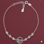 Silver bracelet with a family charm on a red background