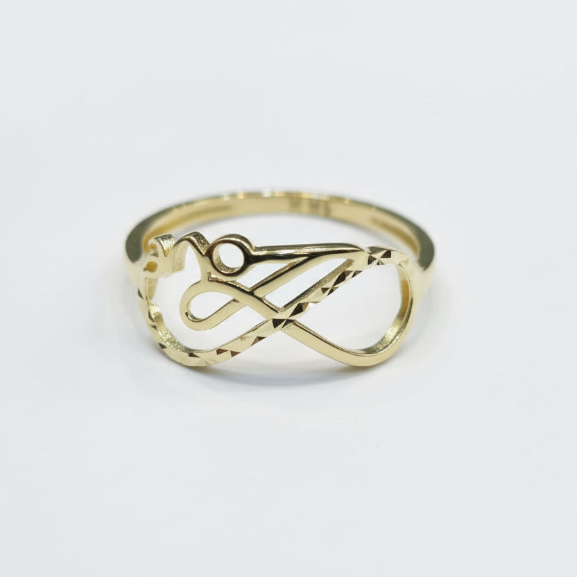 Gold ring with intricate design on a gray background