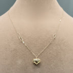Gold heart-shaped pendant necklace on a mannequin with close-up detail.