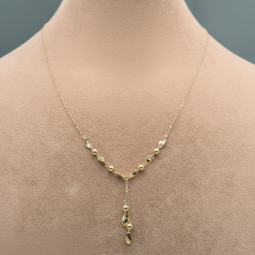 Gold necklace on a mannequin with close-up inset and weight label.
