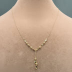 Gold necklace on a mannequin with close-up inset and weight label.