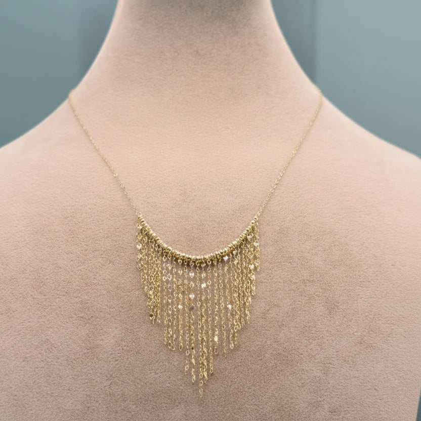 Gold fringe necklace on a mannequin with weight and code information displayed.
