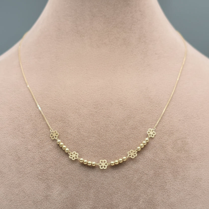 Gold necklace with floral designs on a mannequin neck, showing weight and code.