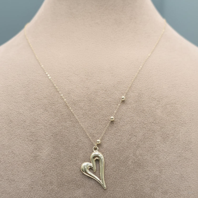 Silver heart-shaped necklace on a mannequin with weight and code information.
