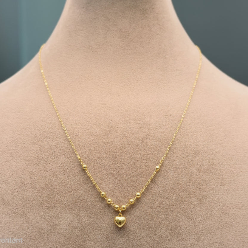Gold necklace with a heart pendant on a mannequin neck, labeled with weight and code.