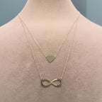 Gold bracelet with infinity pendant on a mannequin