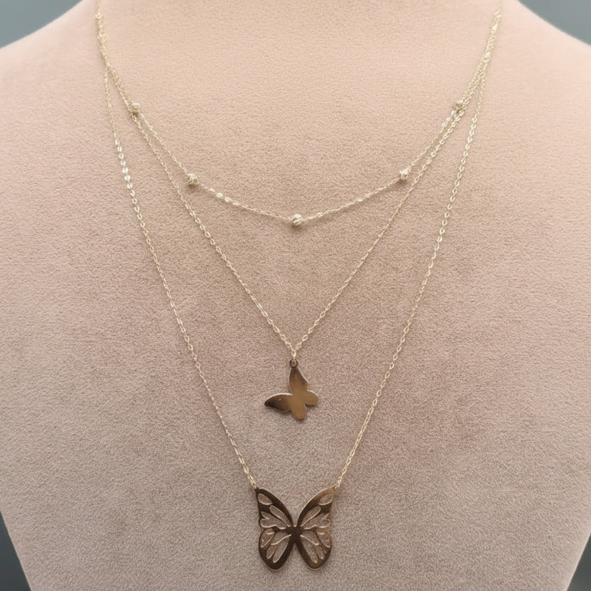Gold butterfly necklace on a mannequin with weight and code displayed.