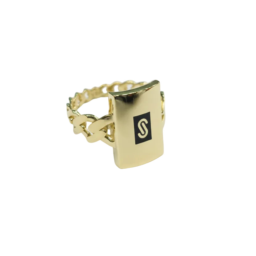 Gold ring with a black square logo on a light gray background