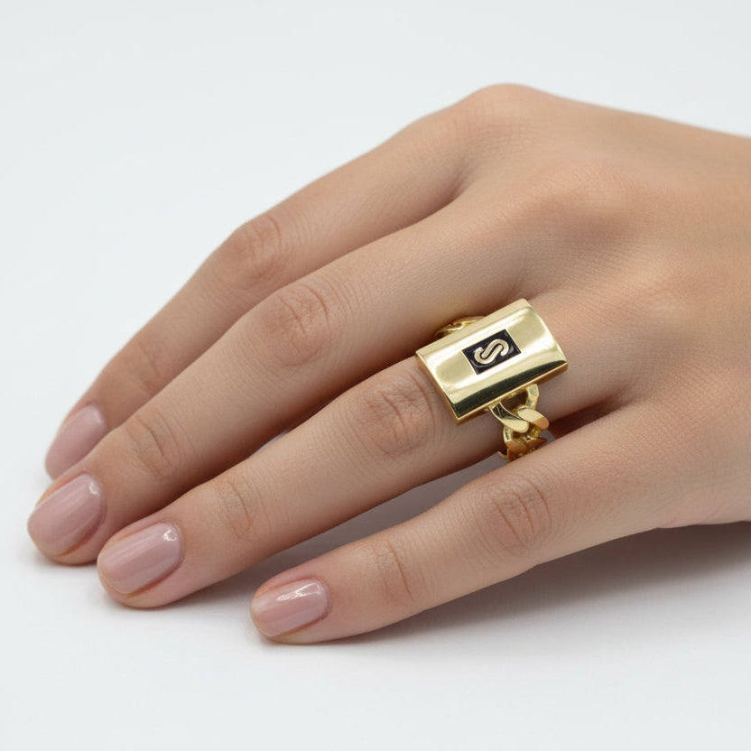 Gold ring with a black square logo on a white background