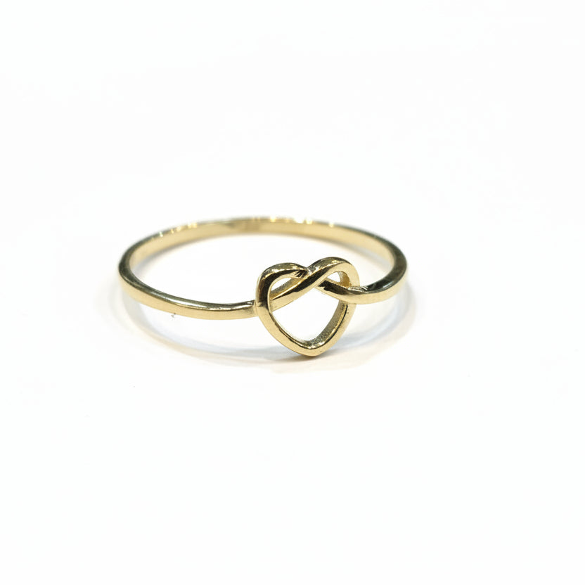 Gold ring with a knot design on a gray background