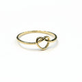 Gold ring with a knot design on a gray background