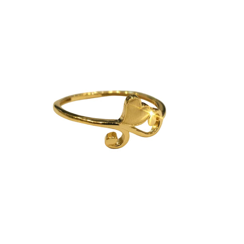 Gold ring with heart design on a gray background