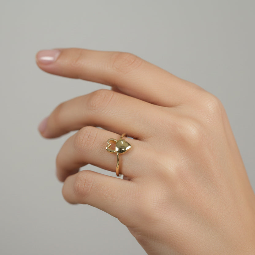 Gold ring with a heart design on a white background