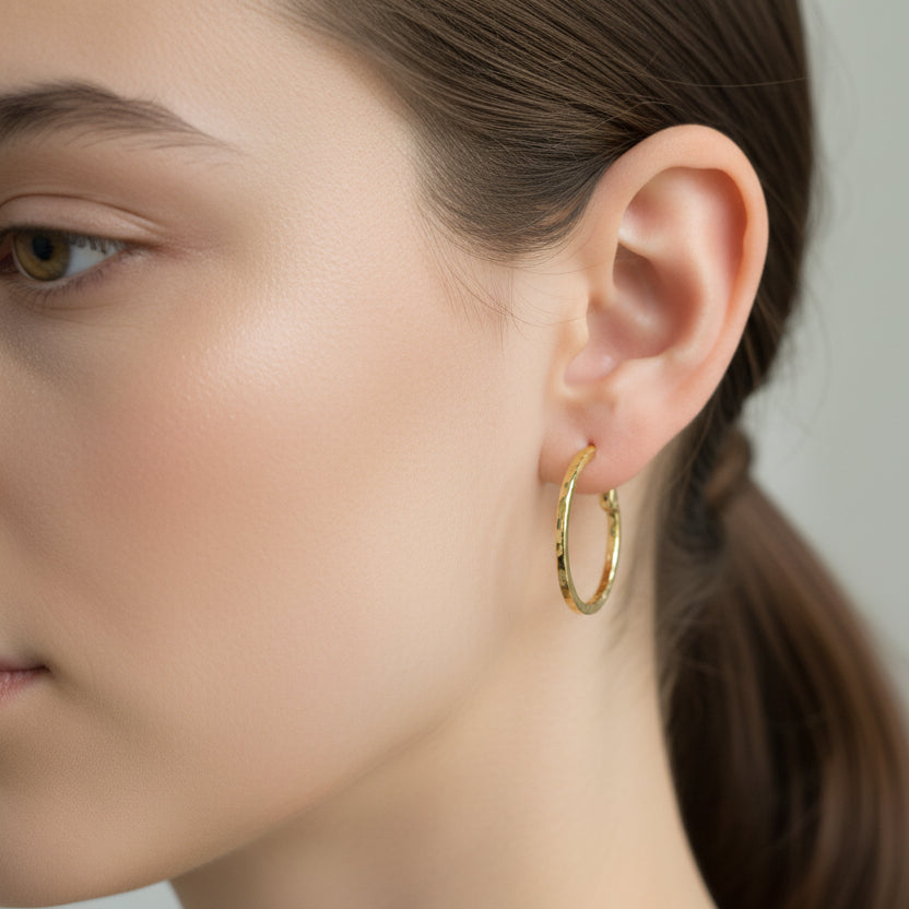Gold hoop earrings on a gray background with weight label.