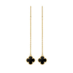 Pair of gold earrings with black clover-like charms on a white background