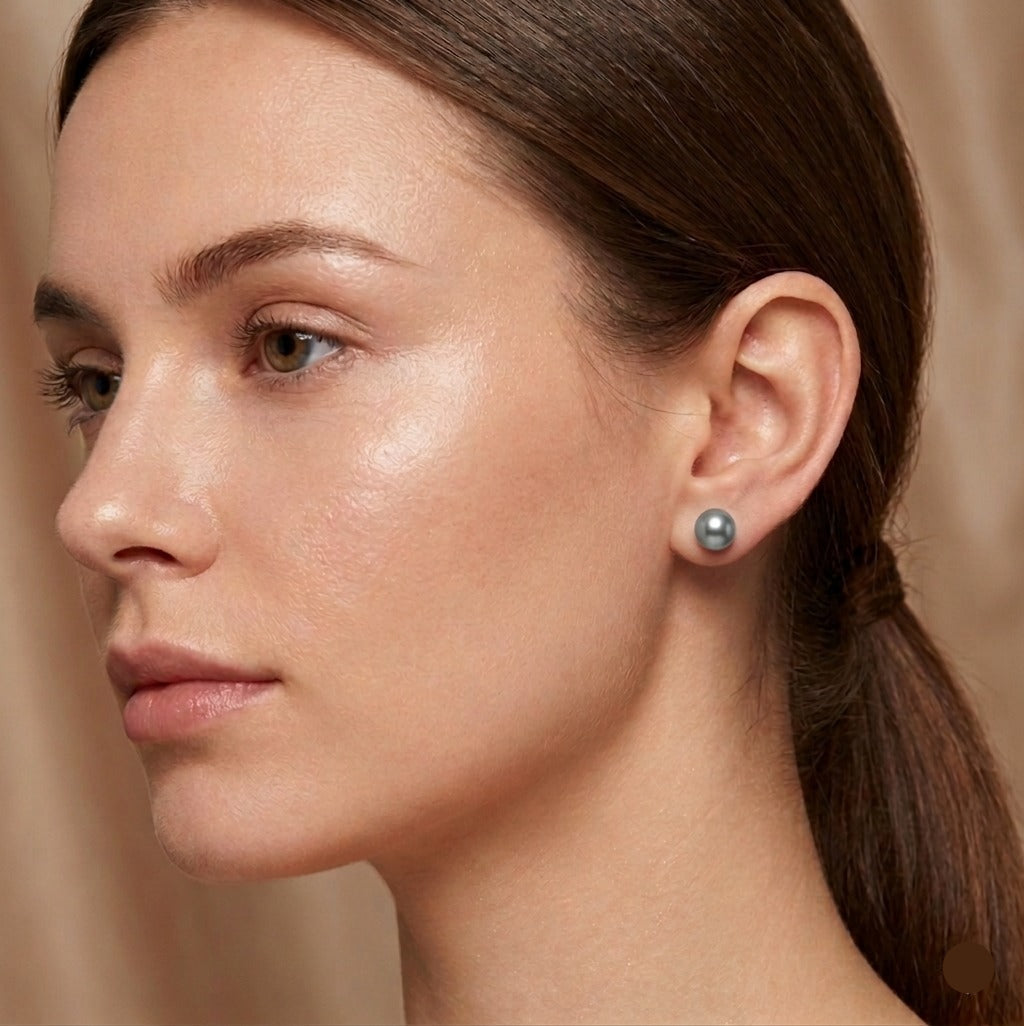 Close-up of a woman wearing a pearl earring against a neutral background