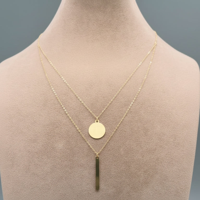 Gold necklace with a green pendant on a mannequin neck, labeled with weight and code.