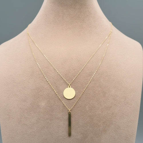 Gold necklace with a green pendant on a mannequin neck, labeled with weight and code.