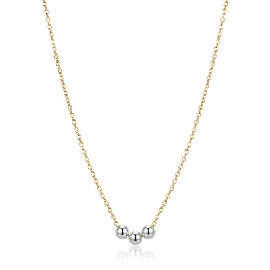 Gold necklace with three silver beads on a white background