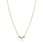 Gold necklace with three silver beads on a white background