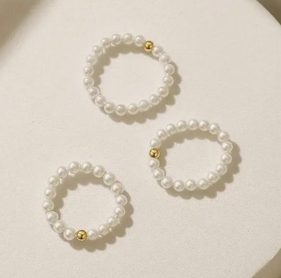 Set of pearl earrings with gold accents on a light background
