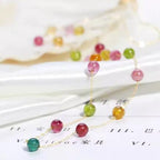 Colorful beaded necklace on a white surface with blurred background