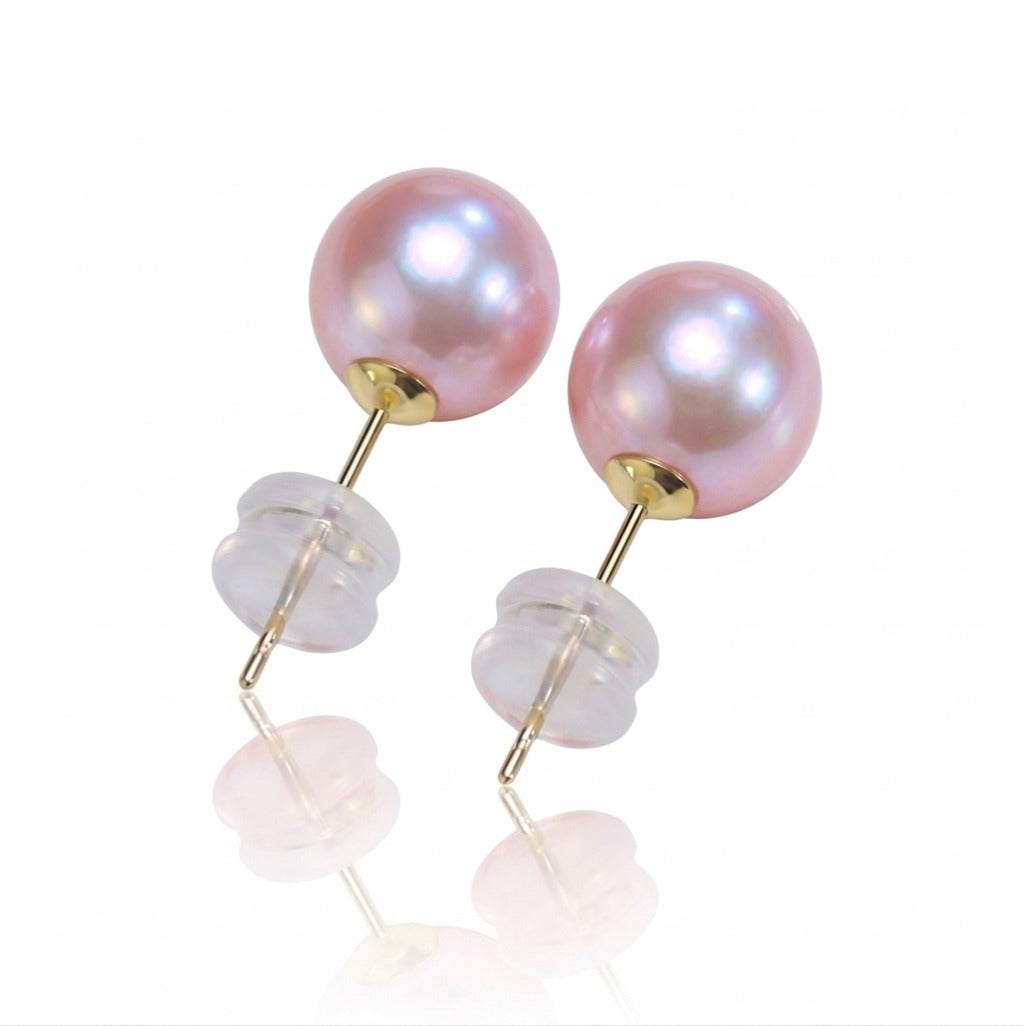 Pair of pink pearl earrings with gold and clear stone accents on a white background