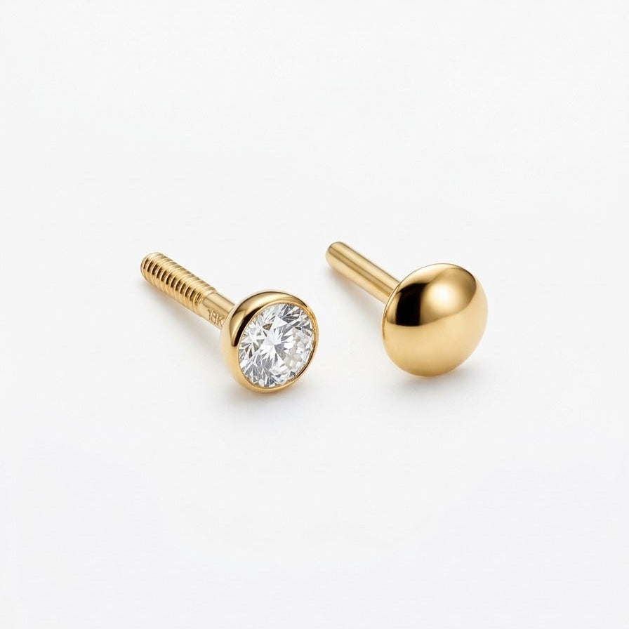 Gold stud earrings with a clear gemstone on a white background