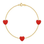 Gold bracelet with red heart-shaped charms on a white background