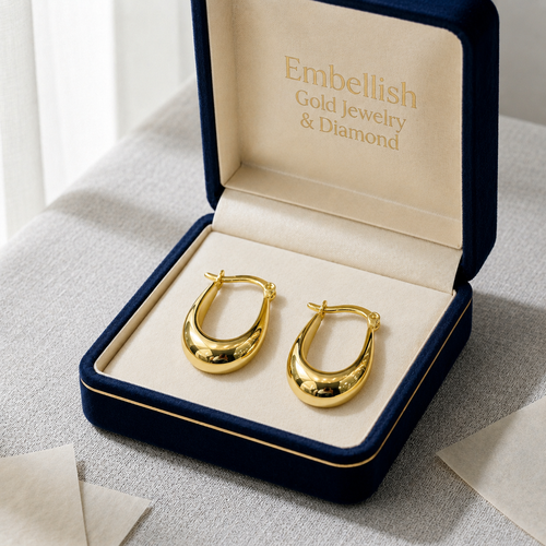 Gold hoop earrings in a 'Embellish Gold Jewelry & Diamond' box on a light surface.