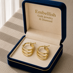 Gold hoop earrings in a 'Embellish Gold Jewelry & Diamond' box on a textured surface.