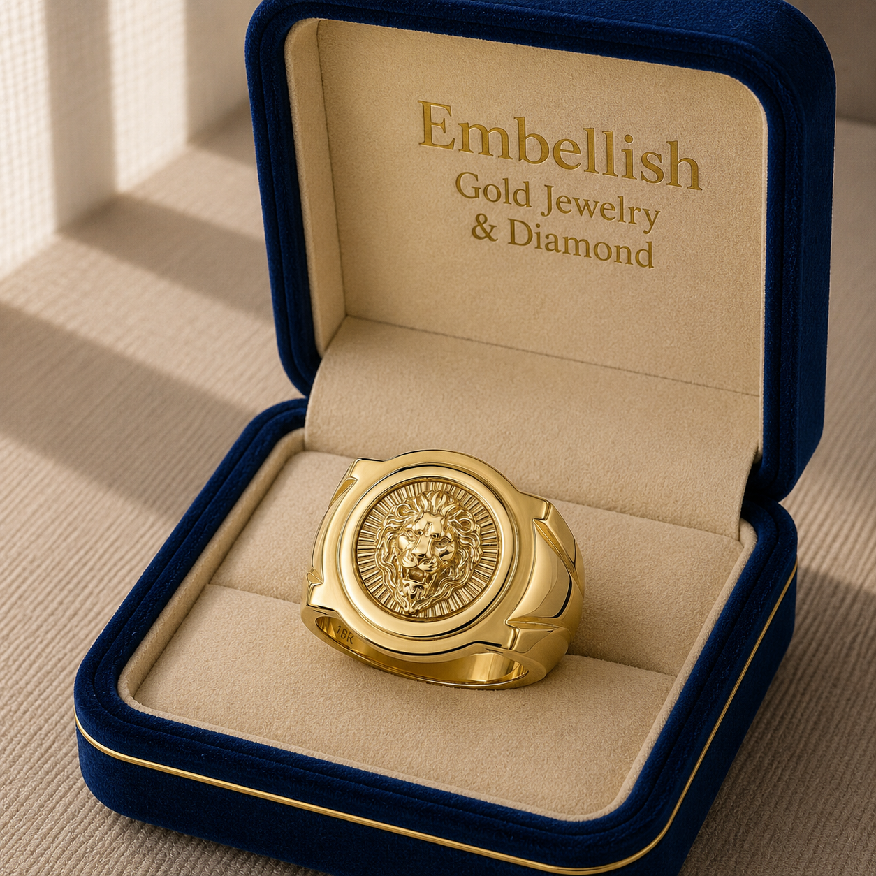 Gold ring with lion head design in a 'Embellish Gold Jewelry & Diamond' box.